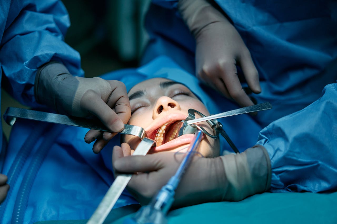 Medical professionals conducting dental surgery on a patient in a clinic setting.